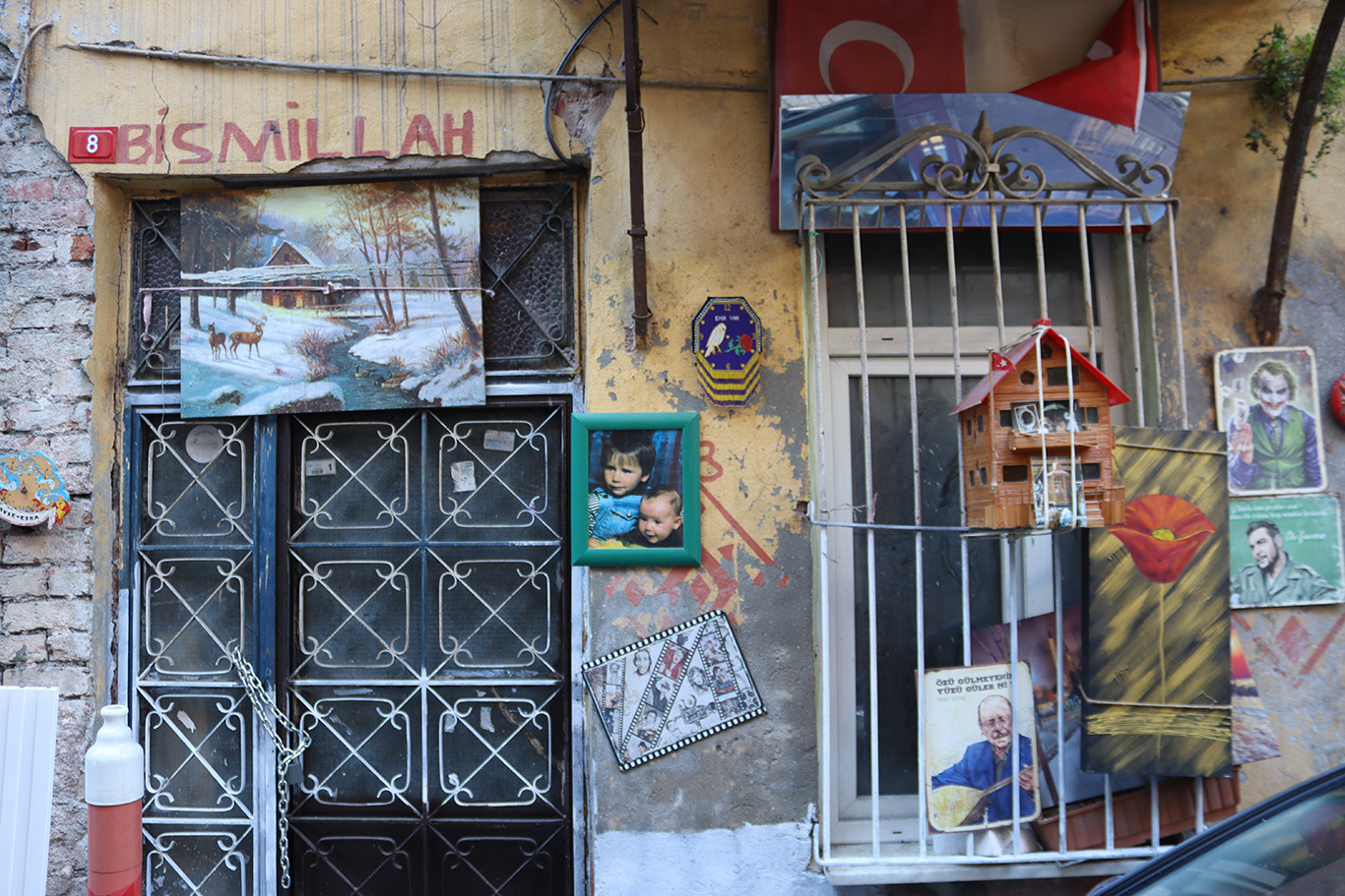 An apartment complex entrance covered with decorative details and posters.