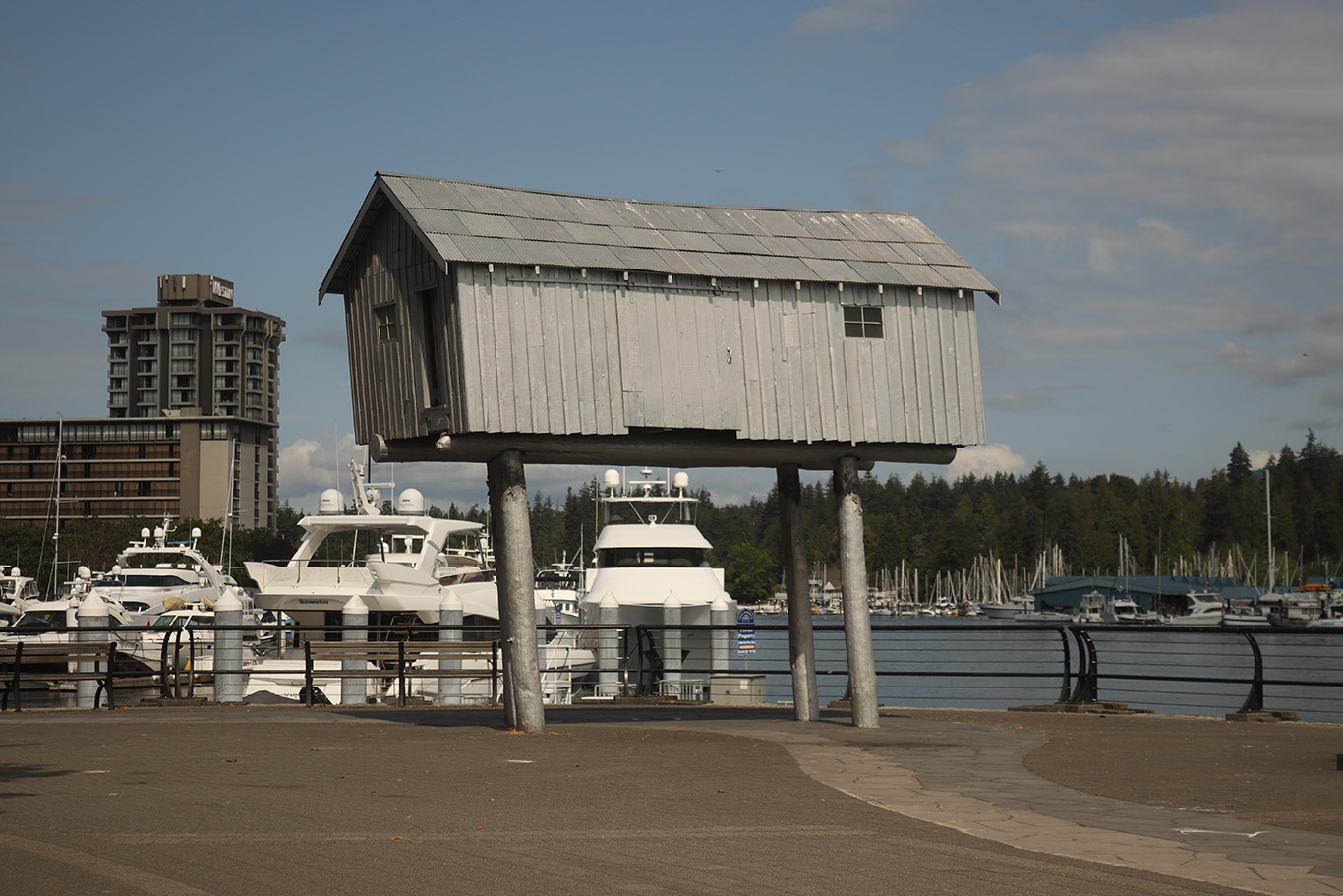 A small cabin on four columns standing in front marina.