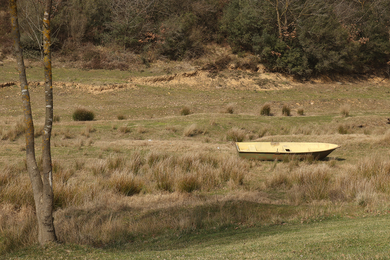 A stranded boat in the middle of an empty field.