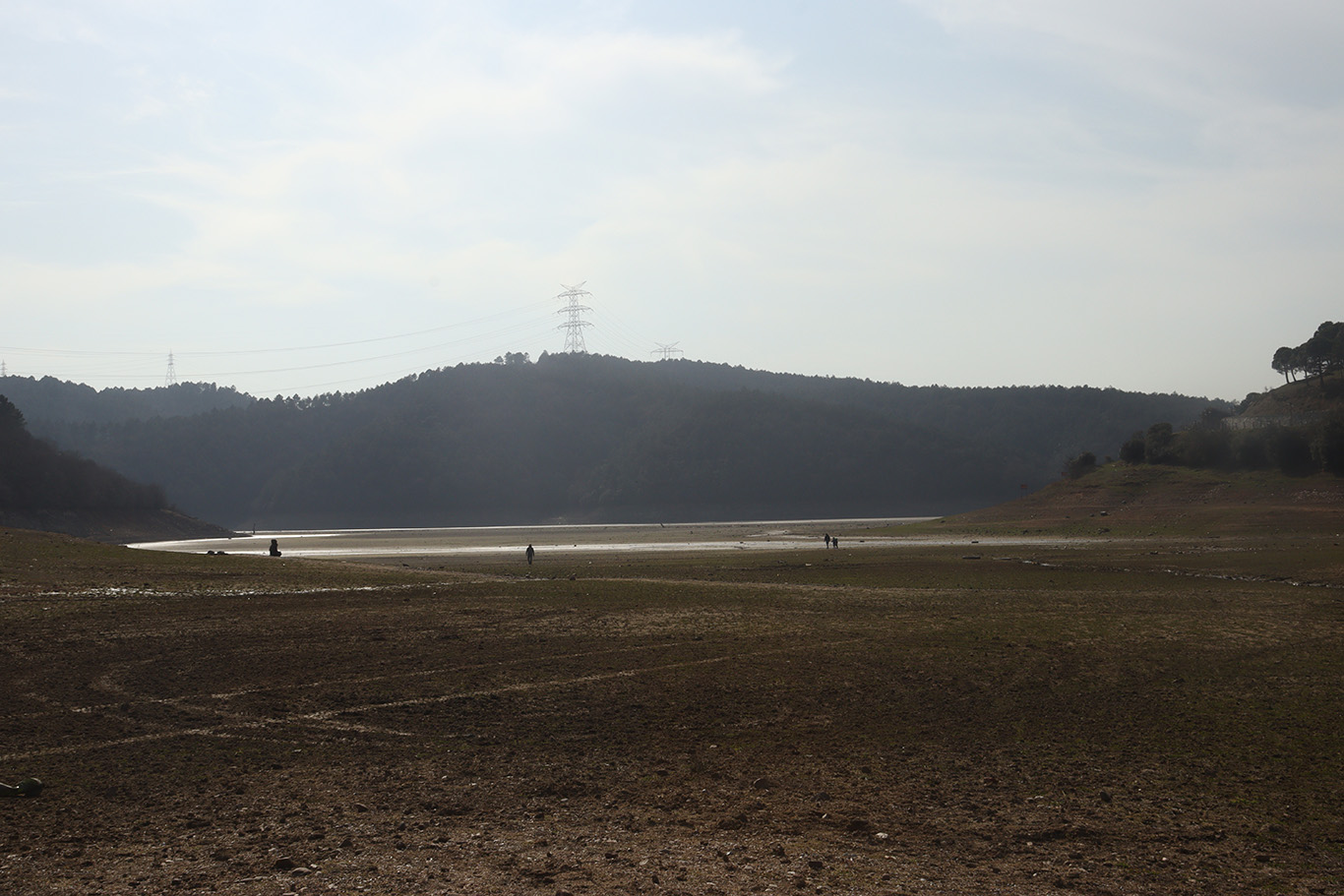 A vast muddy field with a hill in the background.
